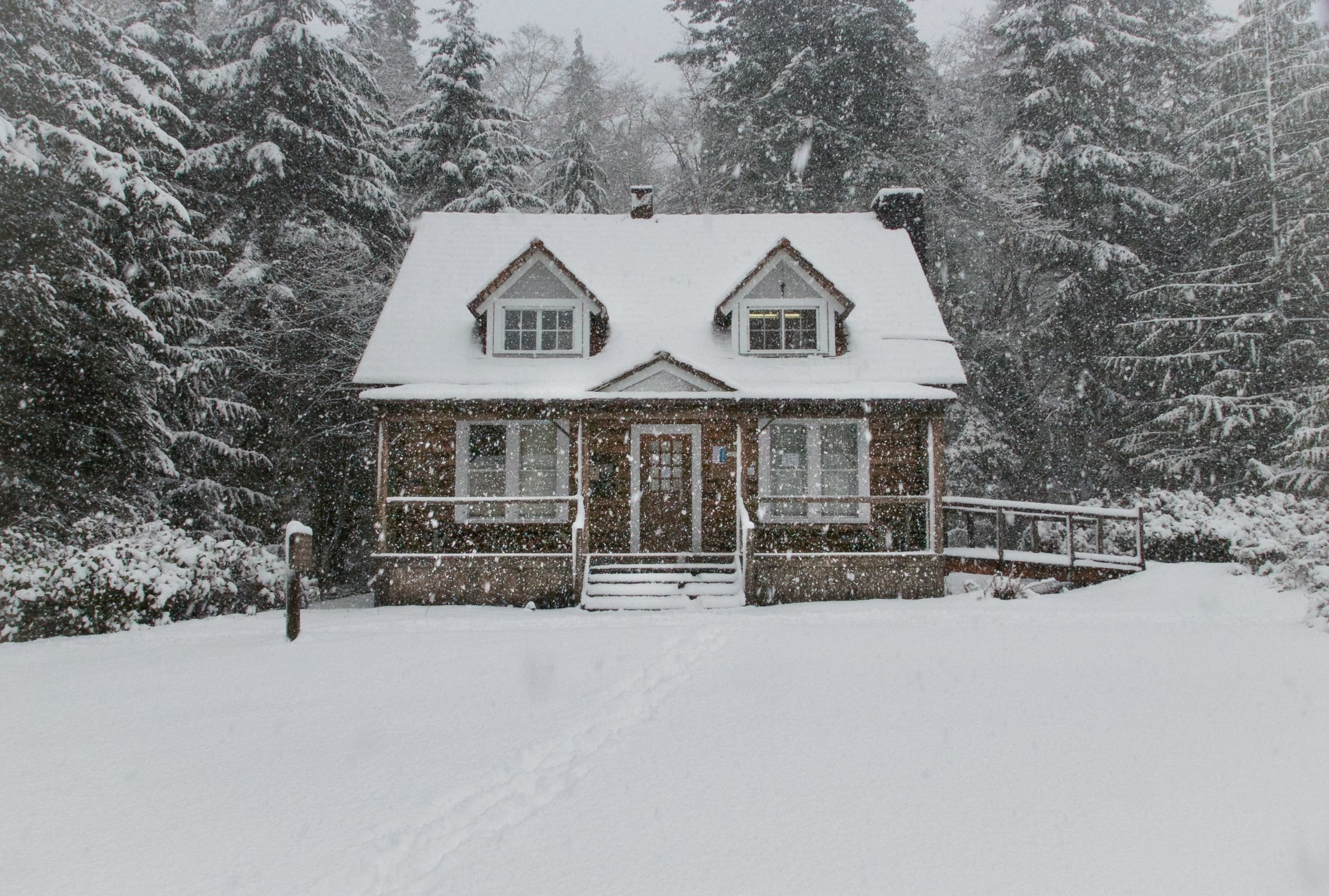 snow falling on snow covered home