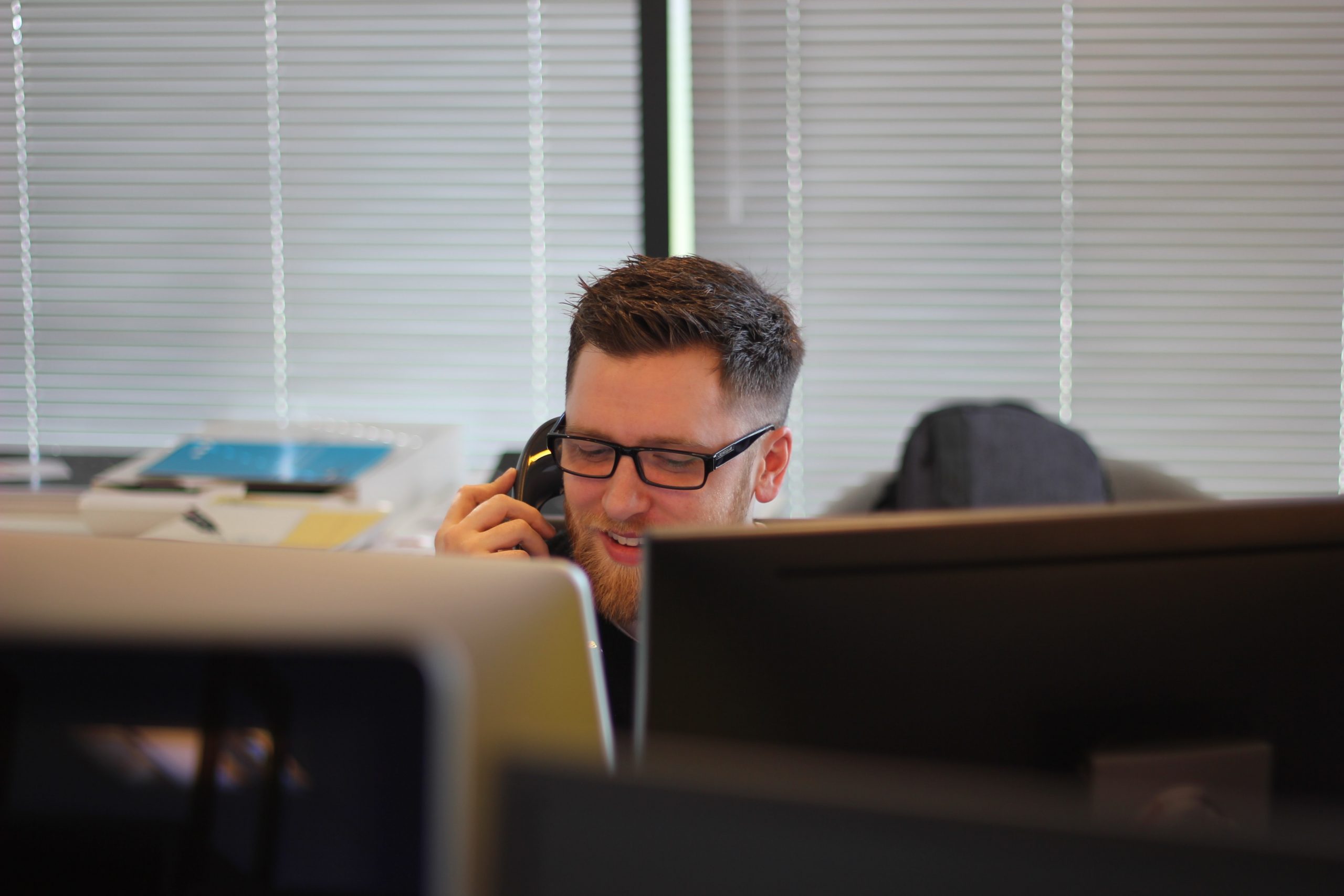 customer phone support man talking on phone behind computer screens