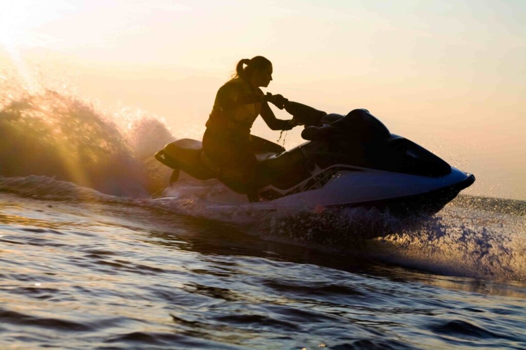 woman riding jetski at sunset