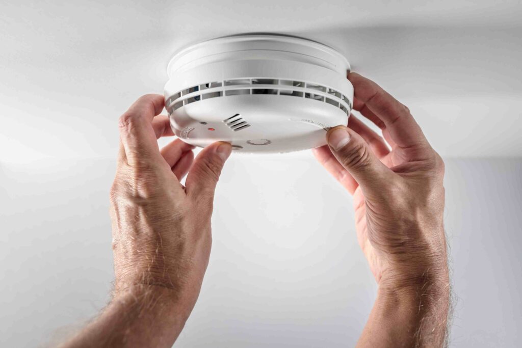 a person is holding a smoke detector in their hands