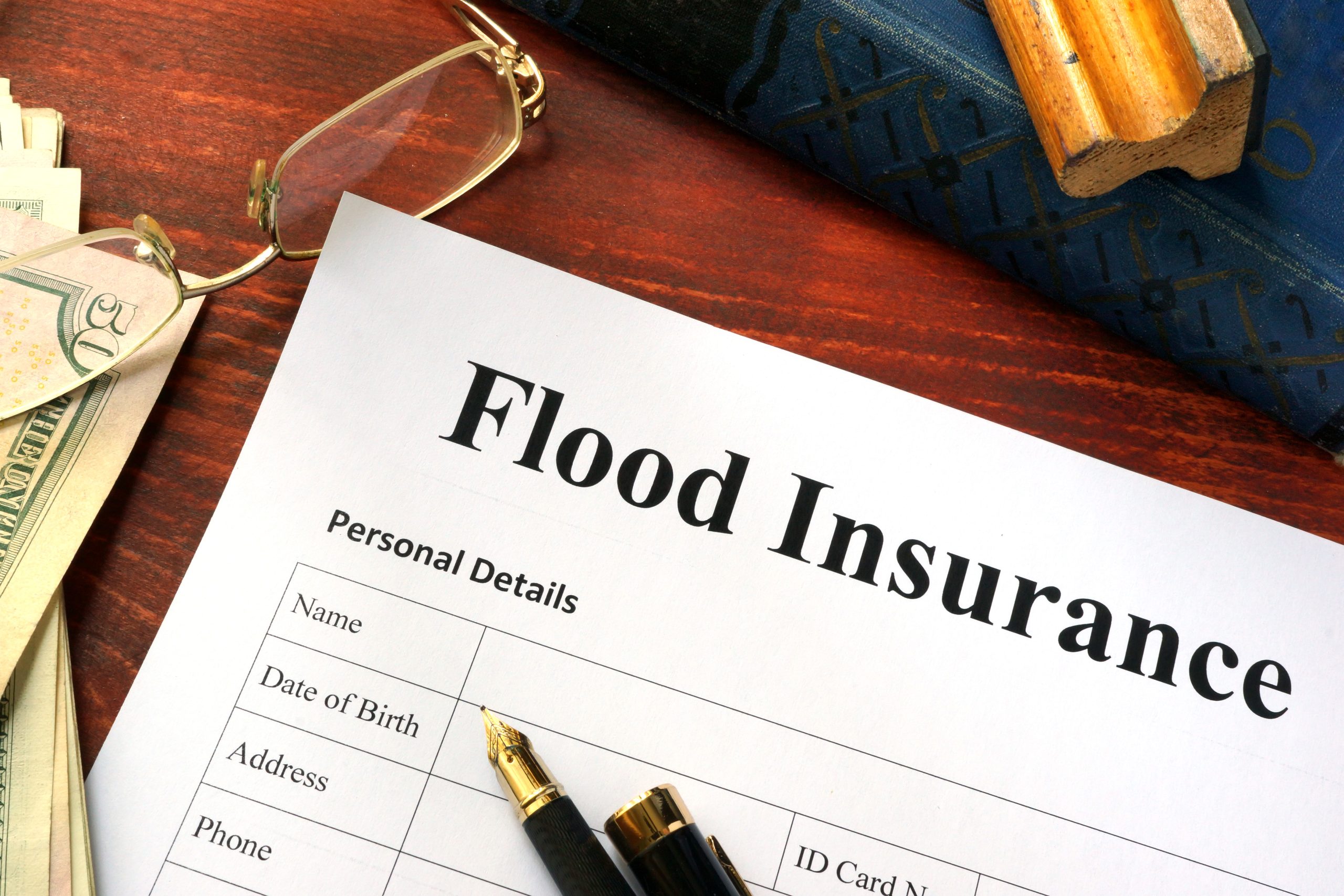 Flood Insurance Form On A Table With A Book.