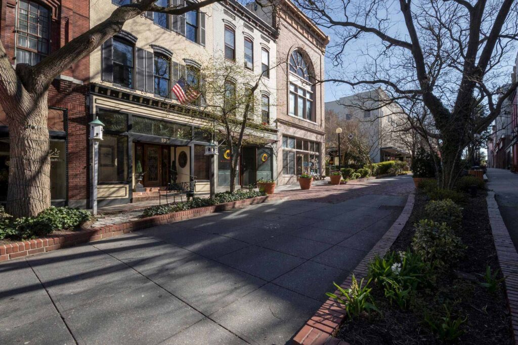 a city street lined with brick buildings and trees