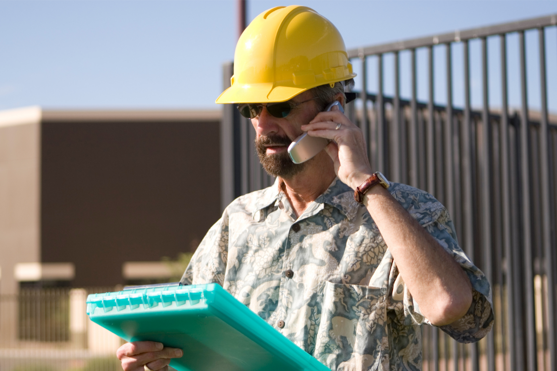 Contractor with a phone and clipboard
