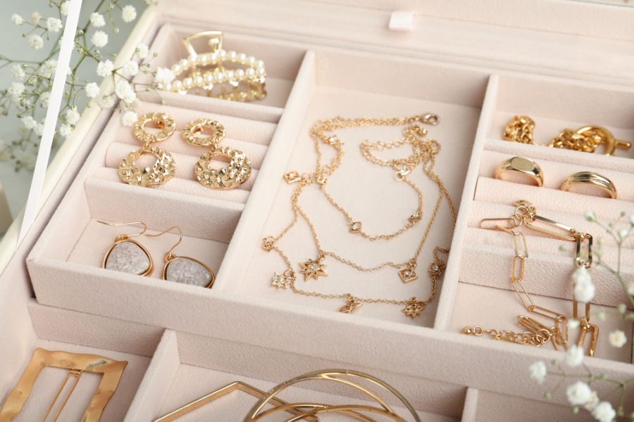 an open jewelry box filled with lots of gold jewelry