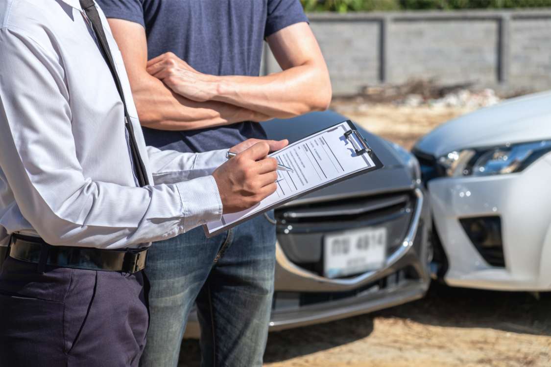 insurance agent examining a car accident