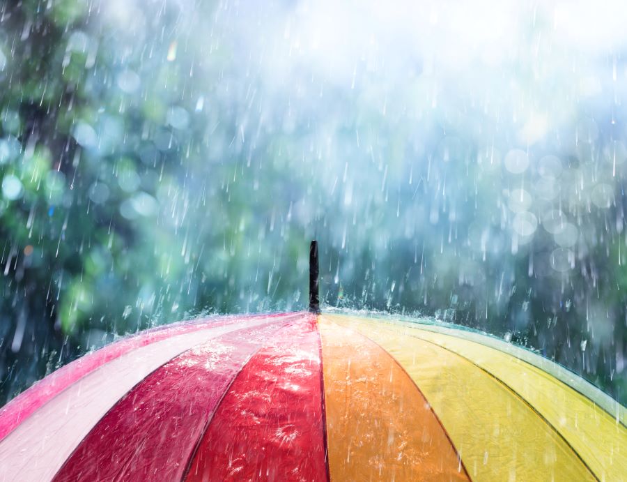 a colorful umbrella sitting in the rain