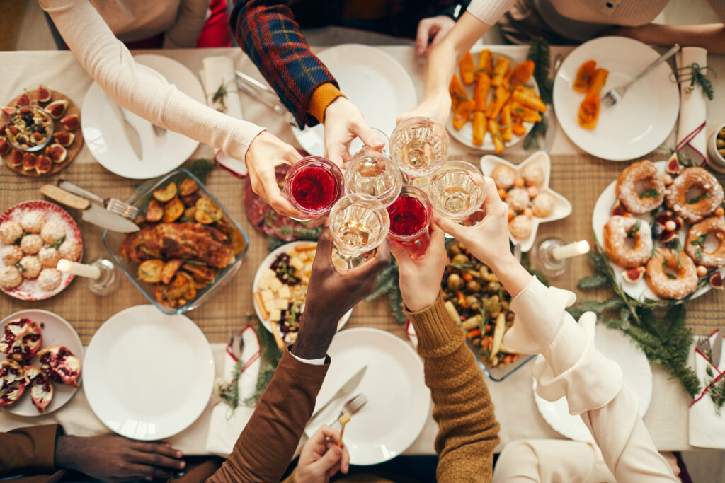 a group of people toasting at a table full of food