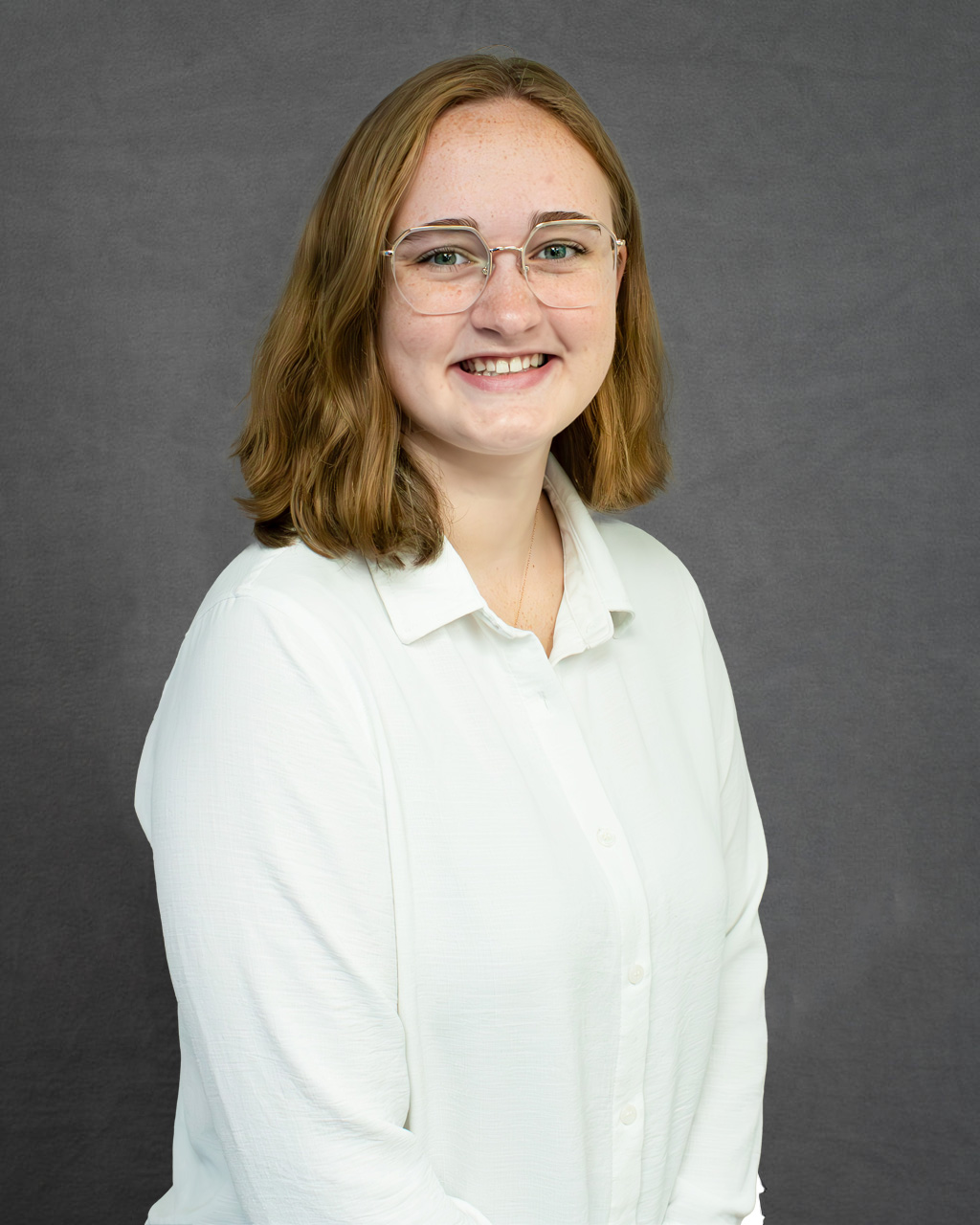 a woman wearing glasses and a white shirt